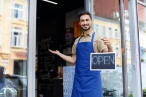 guy with open sign in front of a store