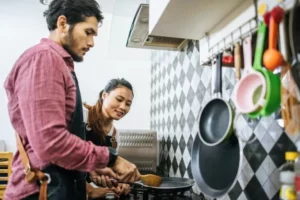 happy young couple helping each other cook